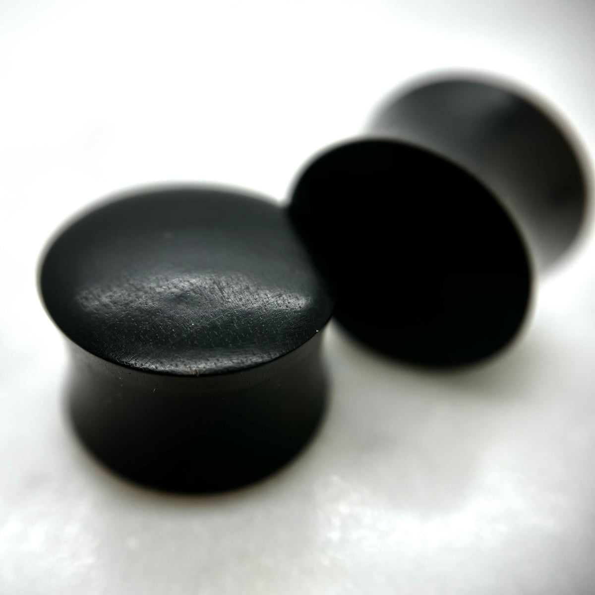 Smooth dark wood plugs with rounded solid fronts