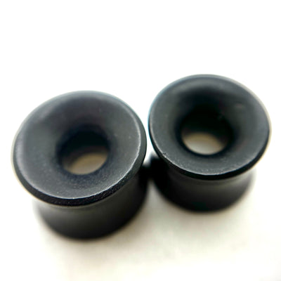 Dark wood tunnels with flared rims and circular openings