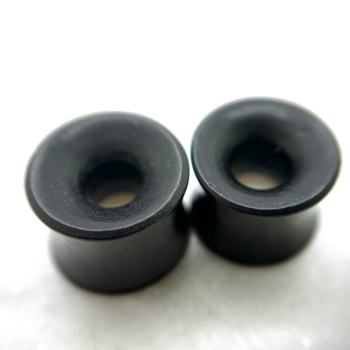 Dark wood tunnels with flared rims and circular openings