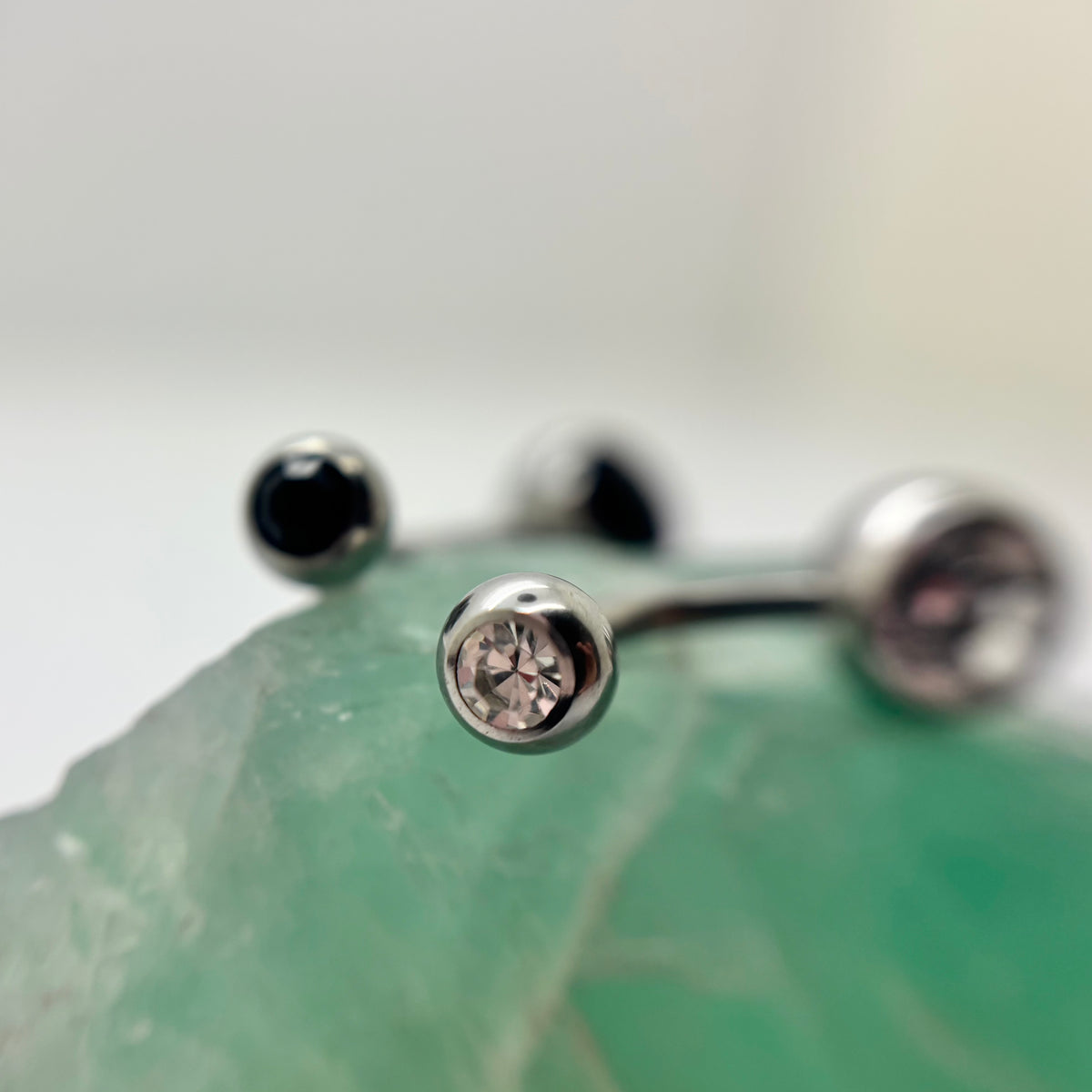 Stainless steel navel bars with clear and black gemstone ends