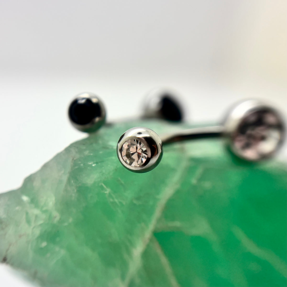 Stainless steel navel bars with clear and black gemstone ends
