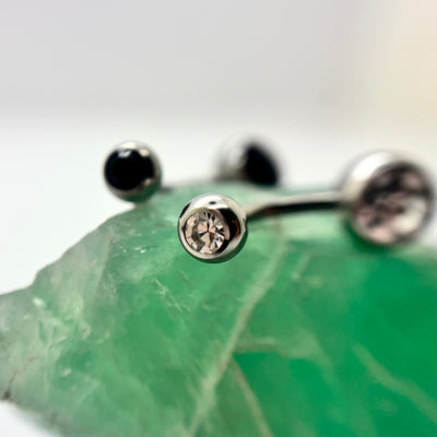 Stainless steel navel bars with clear and black gemstone ends