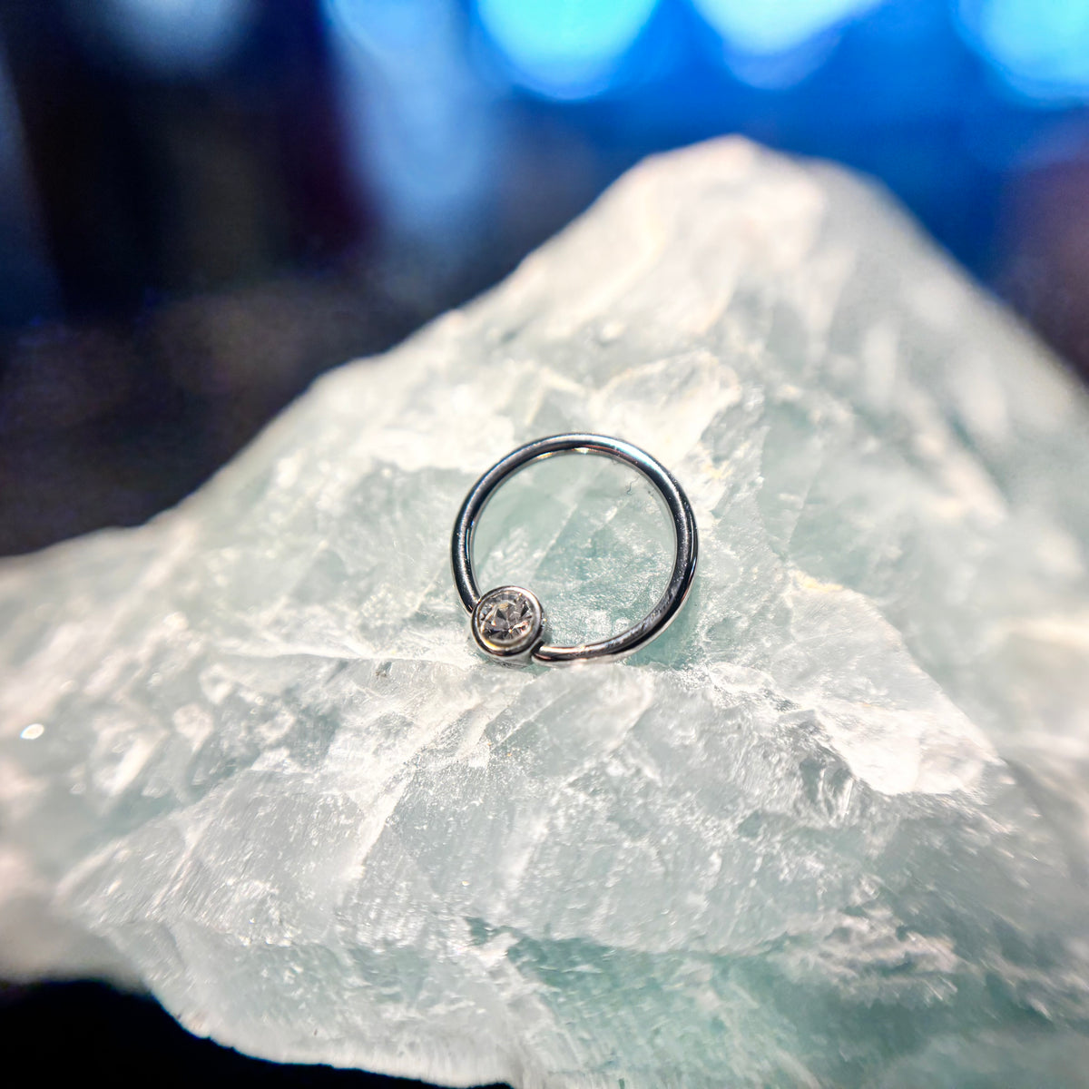 Polished titanium fixed-bead ring on pale stone