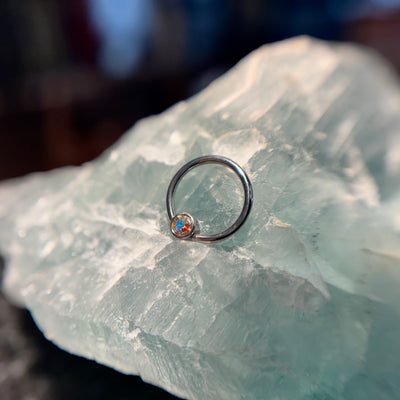 Titanium fixed-bead ring with a pale pink bead on pale stone