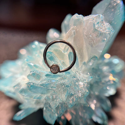 Titanium fixed-bead ring with a bronze-toned bead on blue crystal