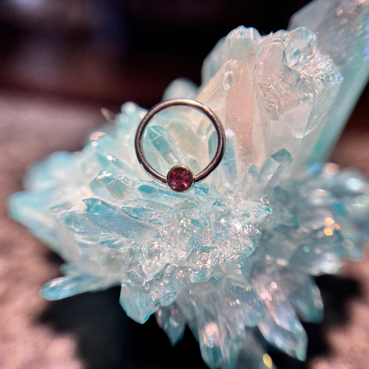 Titanium fixed-bead ring with a pink bead on blue crystal
