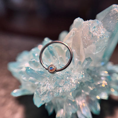 Titanium fixed-bead ring with a pale pink bead on blue crystal