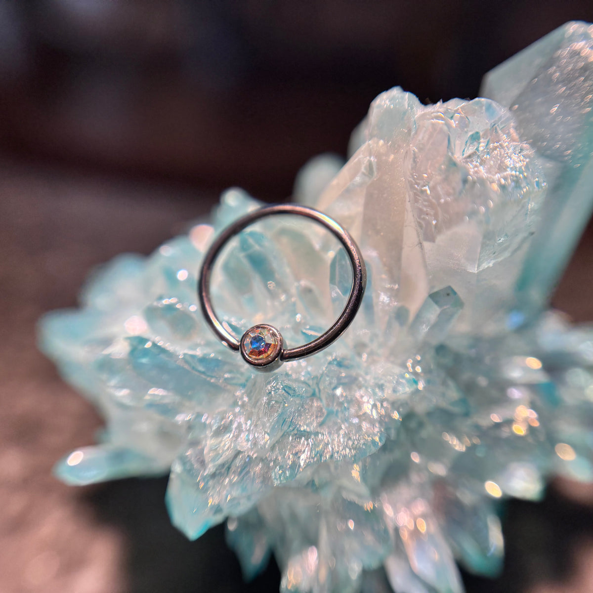 Titanium fixed-bead ring with a pale pink bead on blue crystal