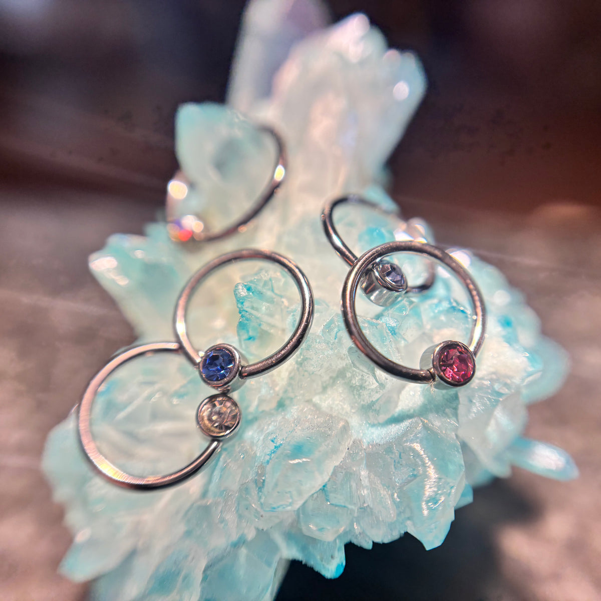 Titanium fixed-bead rings with coloured beads arranged on blue crystal