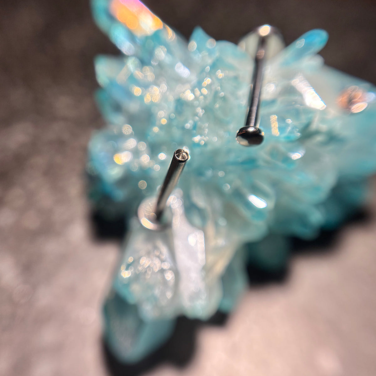 Small stainless steel disc ends and threaded flat-back posts on blue crystal