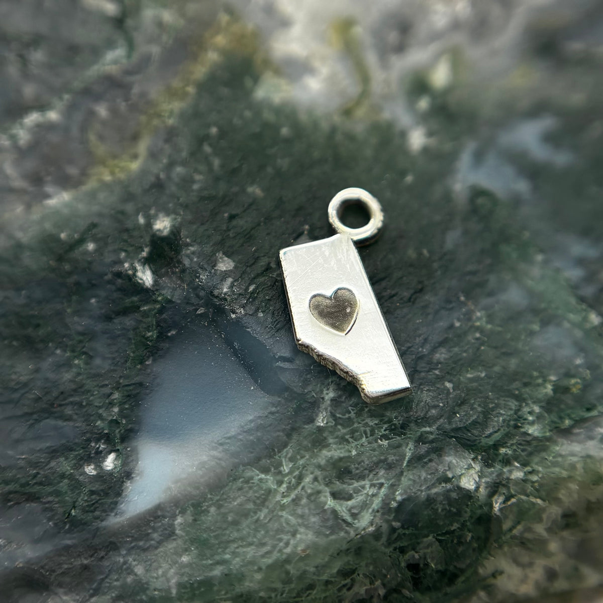 Silver Alberta-shaped charm with a heart cutout and attachment loop