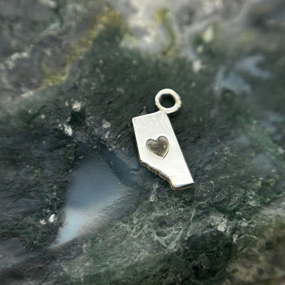 Silver Alberta-shaped charm with a heart cutout and attachment loop