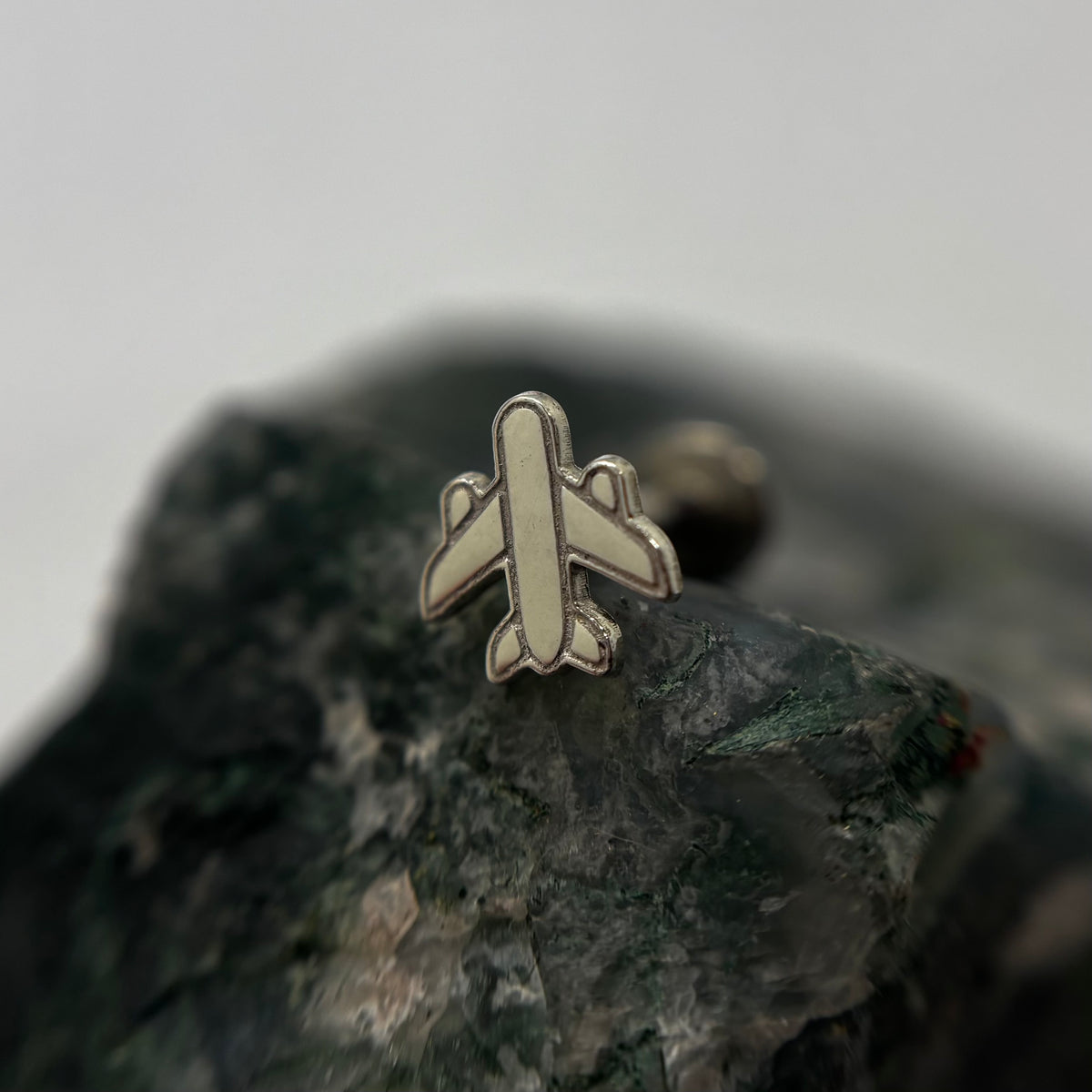 Silver airplane-shaped jewelry end on a flat-back post