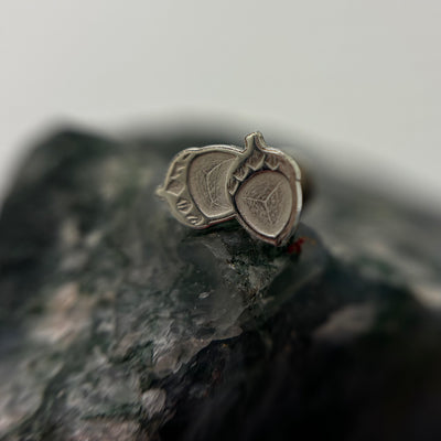 Silver acorn-shaped jewelry end on a flat-back post