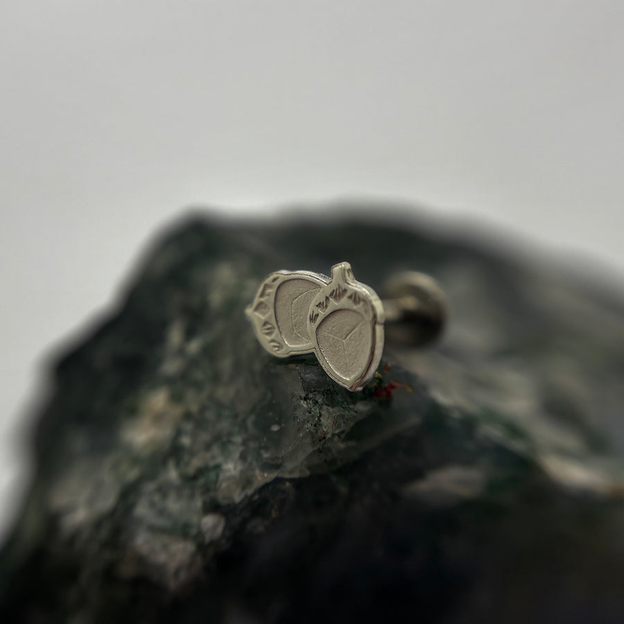Silver acorn-shaped jewelry end on a flat-back post