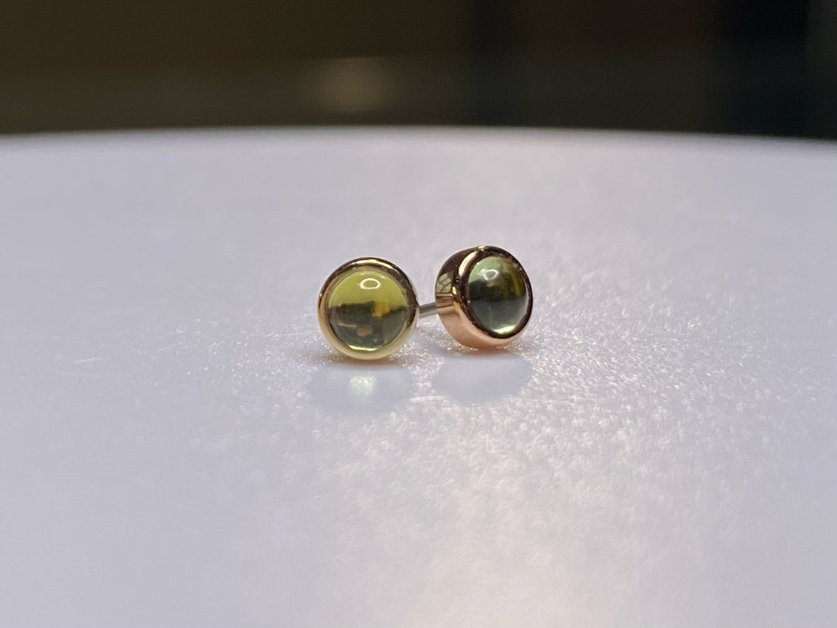 Pair of green peridot studs in yellow and rose gold settings