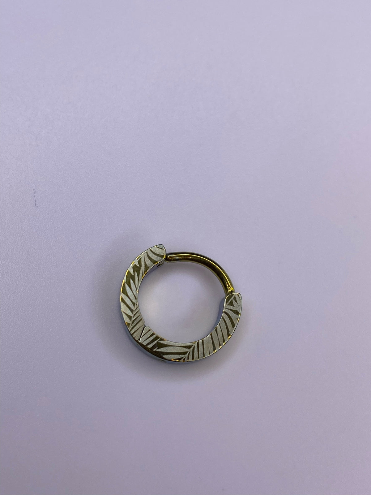 Palm Leaf titanium clicker with a gold-toned leaf pattern