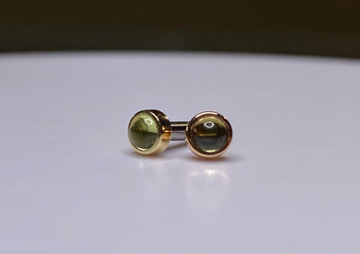 Pair of green peridot studs in yellow and rose gold settings