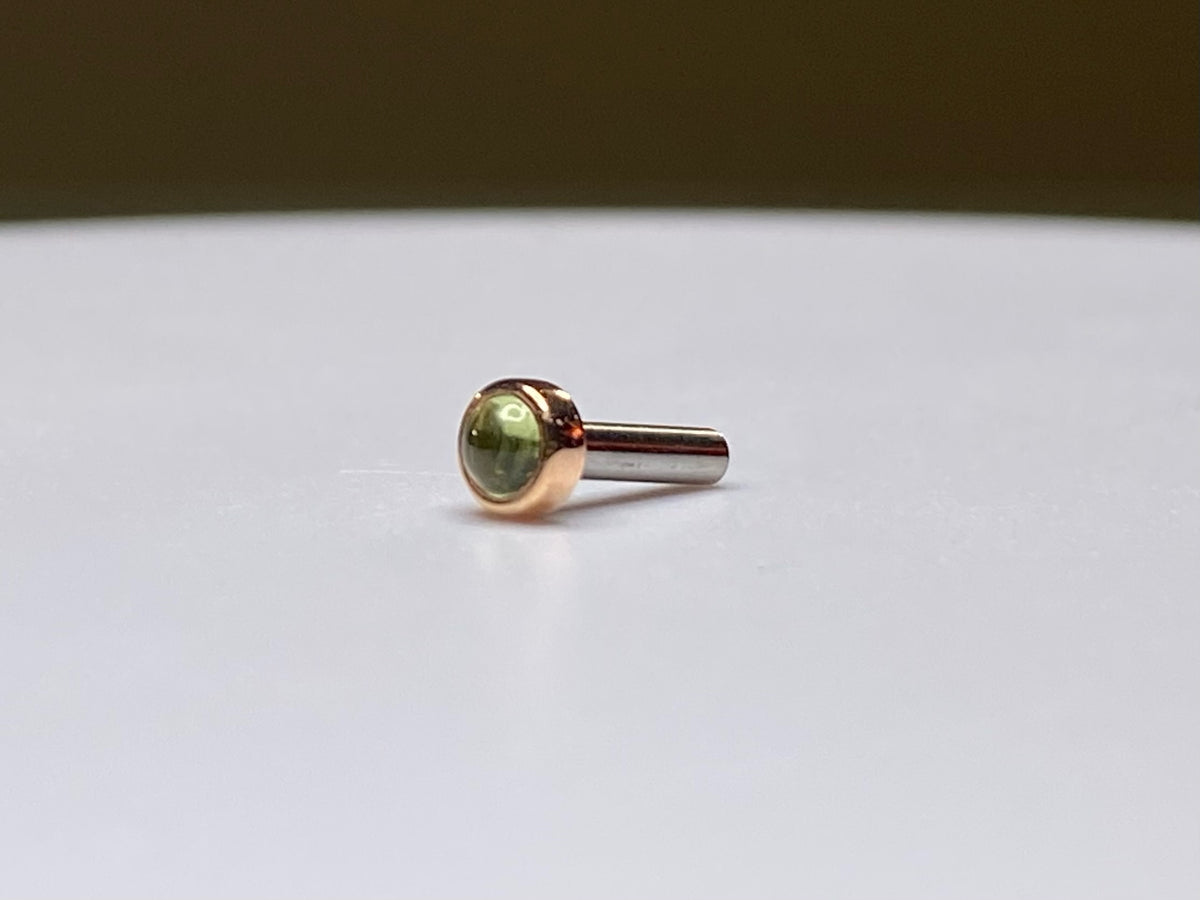 Rose gold threadless stud with a green peridot cabochon