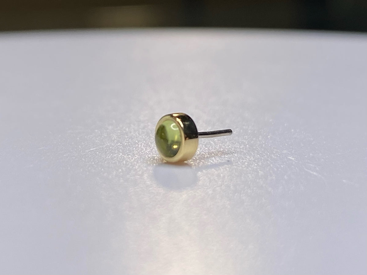Yellow gold threadless stud with a green peridot cabochon