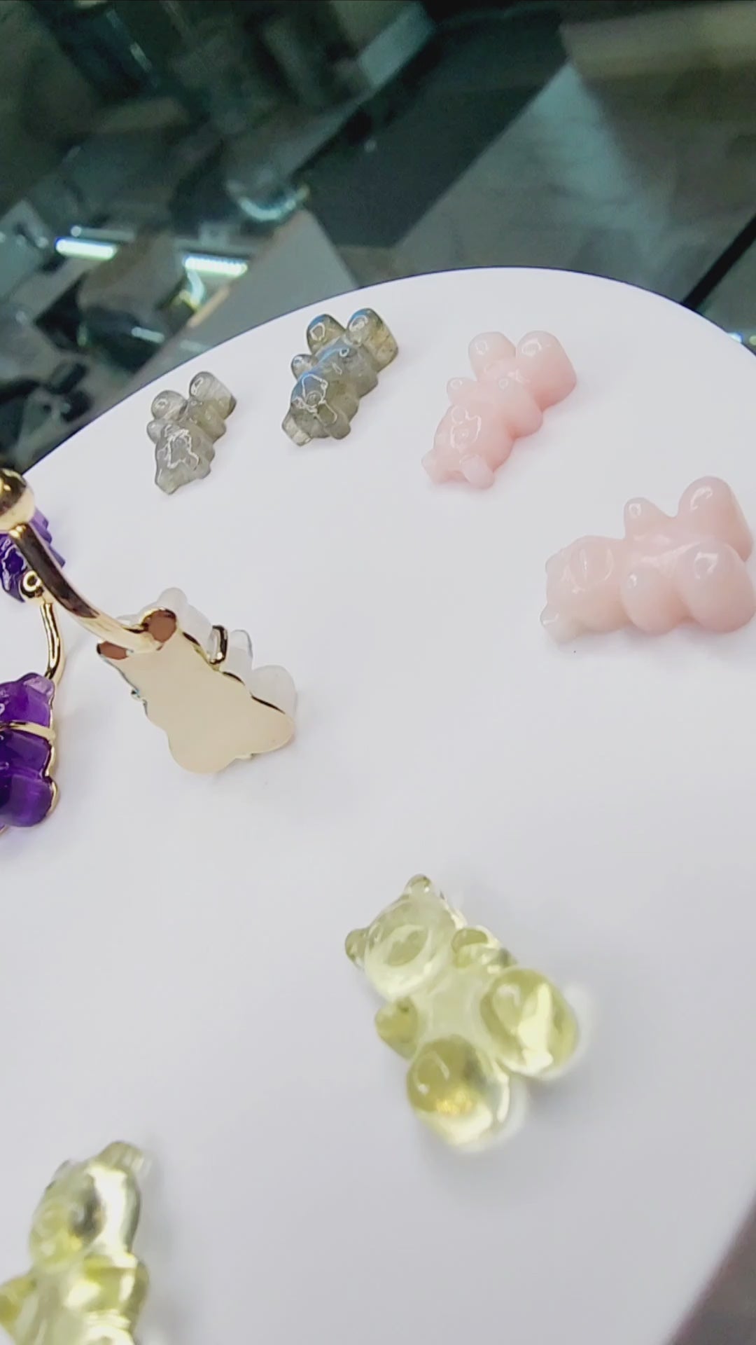 Colourful gummy bear gemstone navel jewelry on a round display
