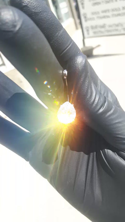 Prong-set titanium gemstone jewelry held in a gloved hand