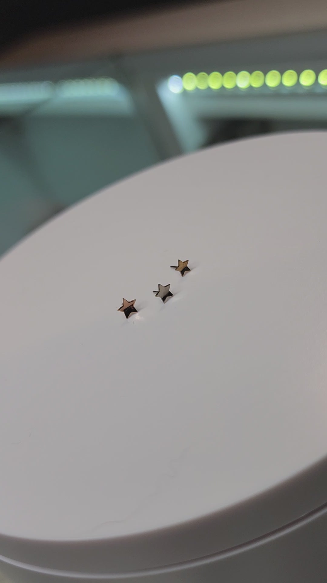 Curved gold star-shaped jewelry ends on a round display