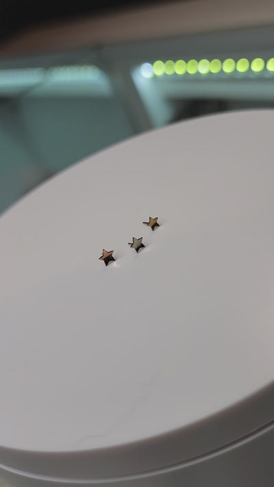 Curved gold star-shaped jewelry ends on a round display