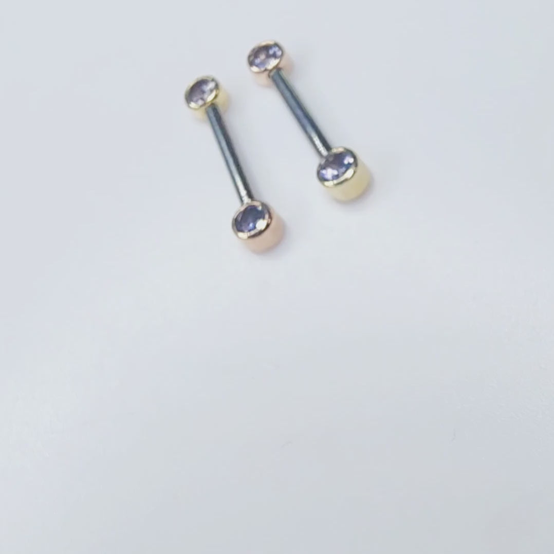 Front-facing barbells with iolite gemstones in gold settings