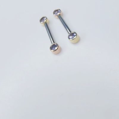Front-facing barbells with iolite gemstones in gold settings