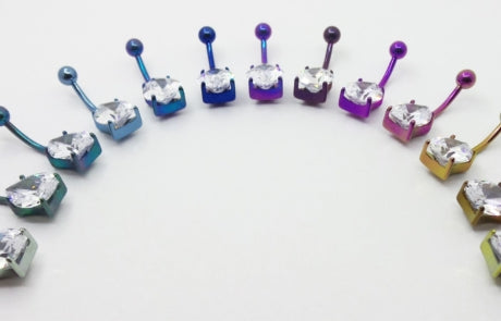 Teardrop gemstone titanium navel bars arranged by anodized colour
