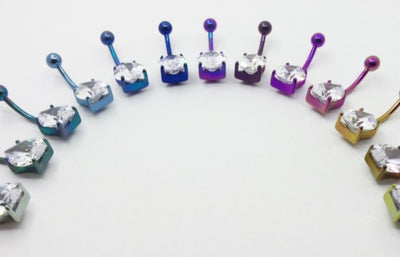 Teardrop gemstone titanium navel bars arranged by anodized colour