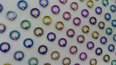 Multicoloured captive bead rings arranged in rows