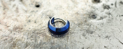 Blue patterned titanium clicker on a pale stone surface