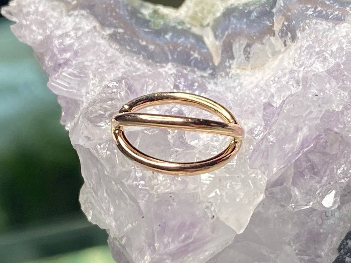 Yellow gold split seam ring displayed on pale crystal