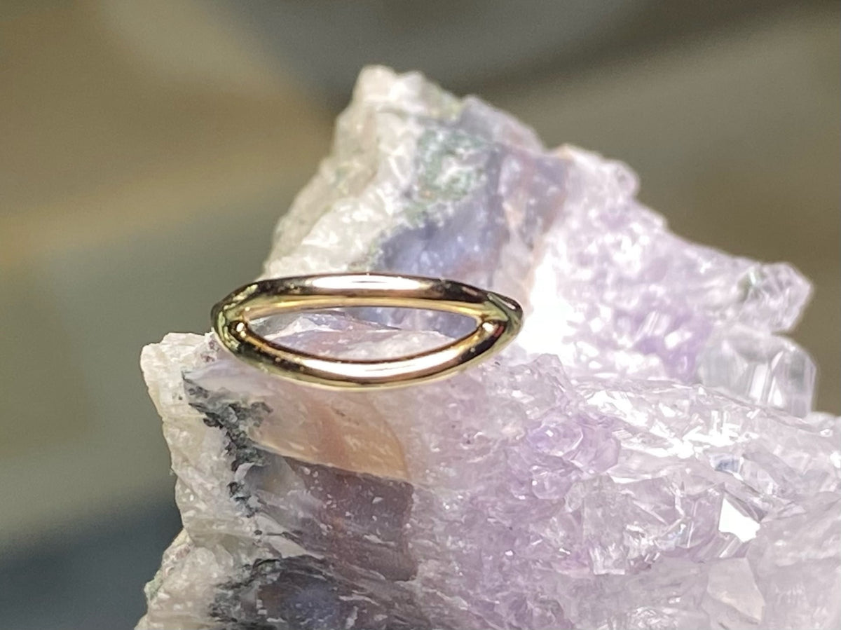 Yellow gold split seam ring displayed on pale crystal