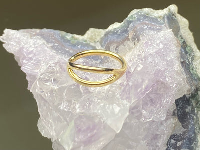 Yellow gold split seam ring displayed on pale crystal