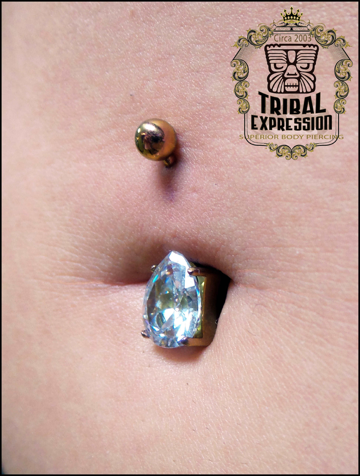 Blue teardrop gemstone titanium jewelry worn in a navel piercing