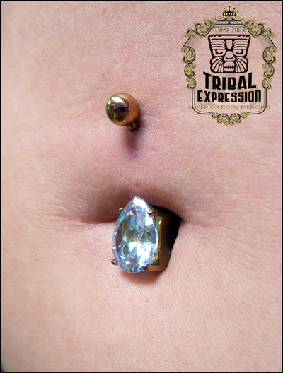 Blue teardrop gemstone titanium jewelry worn in a navel piercing