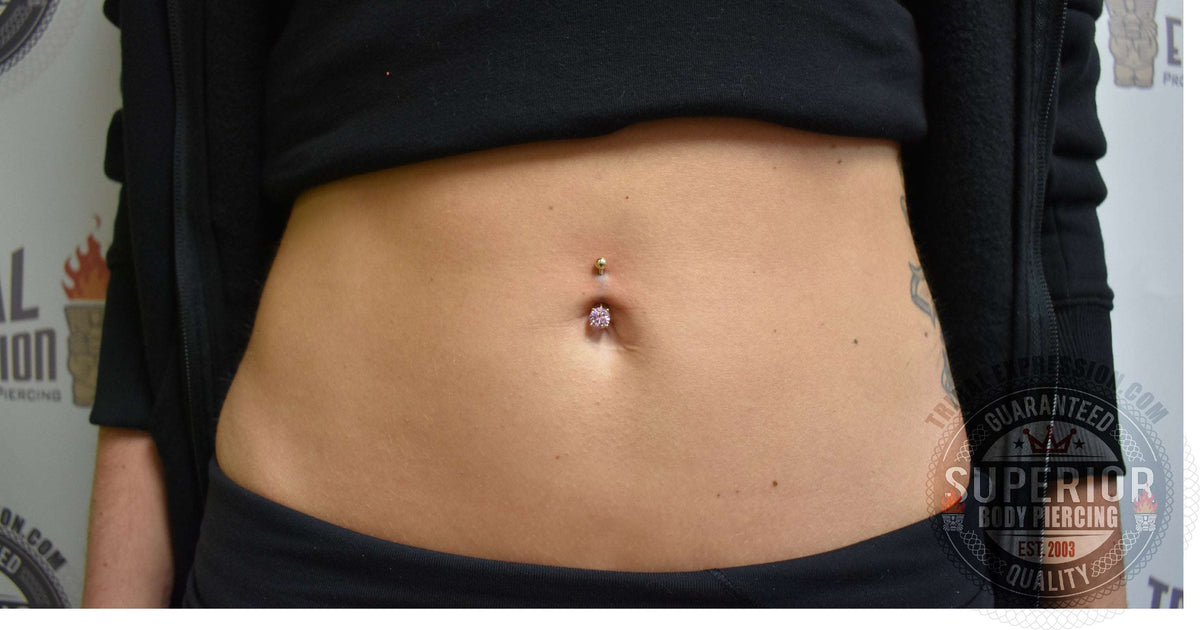 Curved navel barbell worn above blue jeans