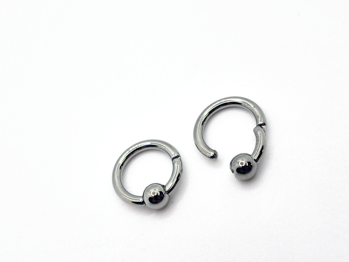 Polished titanium captive bead rings shown open and closed