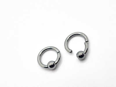 Polished titanium captive bead rings shown open and closed